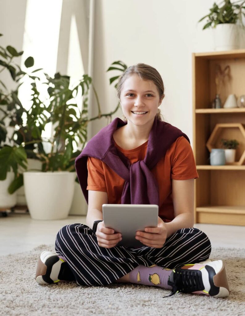 Teen sitting on floor with tablet