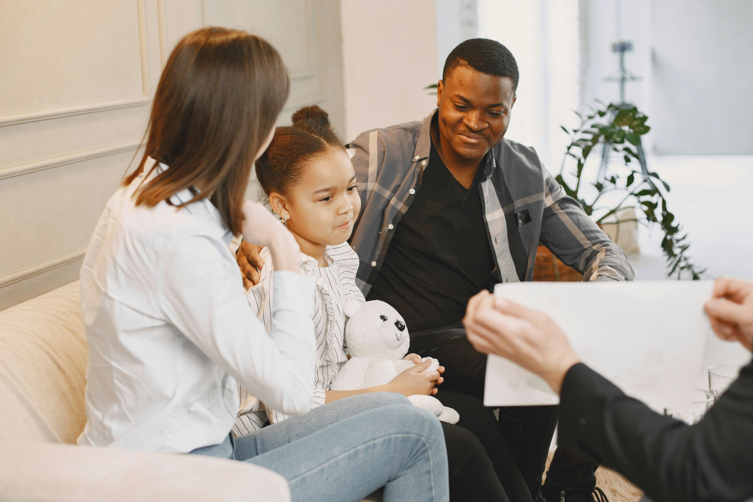 Modern Family Therapy Techniques in 2025. A family sits in during a therapy session where the therapist holds up a piece of paper.