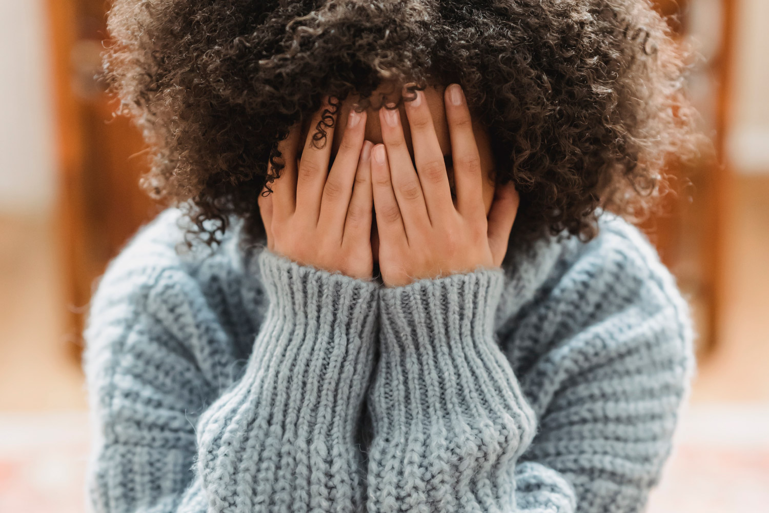 Emotional Dysregulation in Children & Teens a girl has her head in her hands showing a stress response